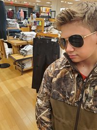 Portrait of young man wearing sunglasses standing at home