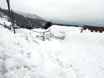 Snow covered land and mountains against sky