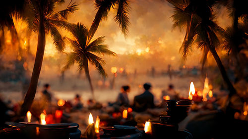 Close-up of illuminated candles against sky during sunset