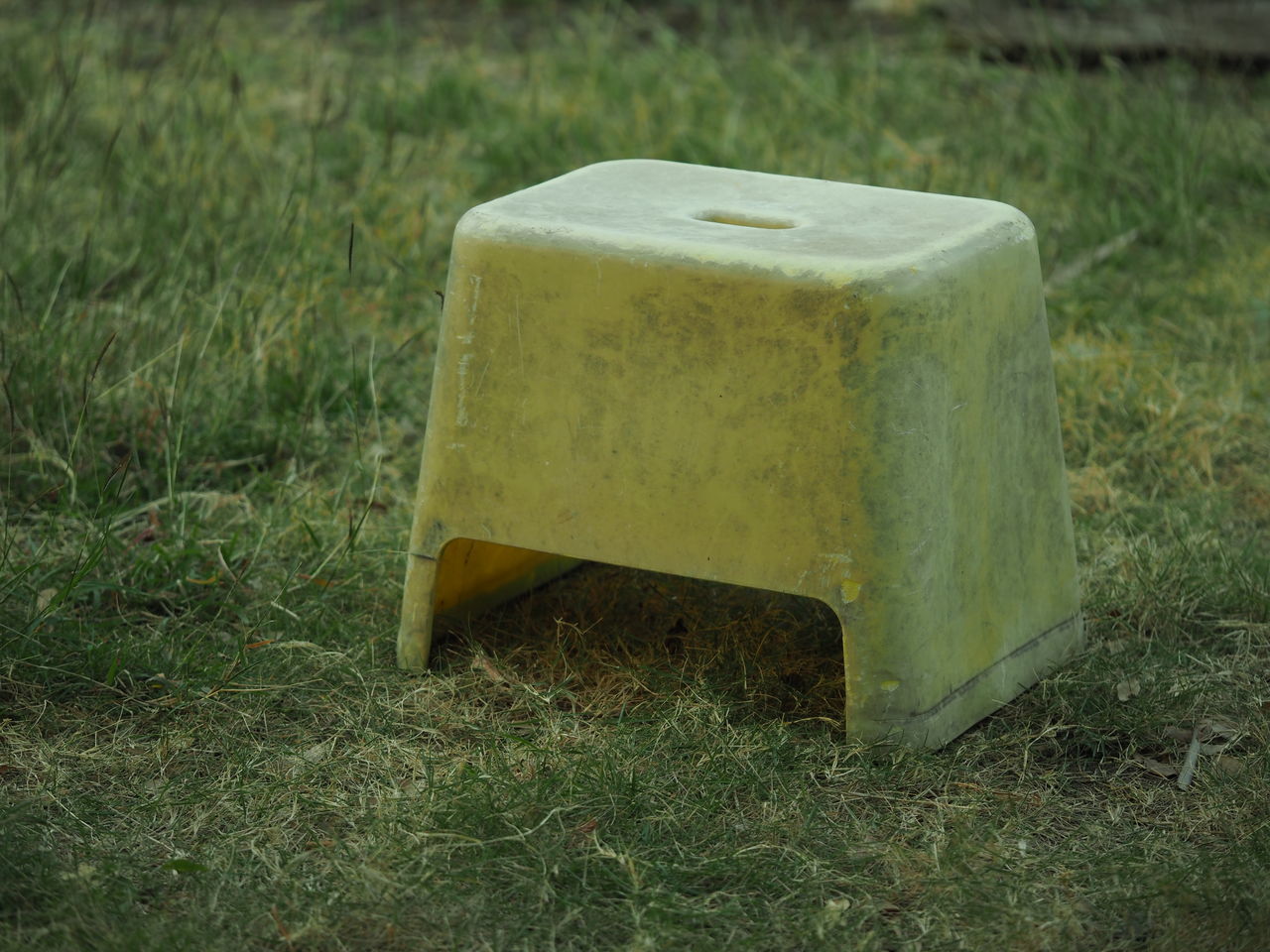 HIGH ANGLE VIEW OF YELLOW CONTAINER ON FIELD