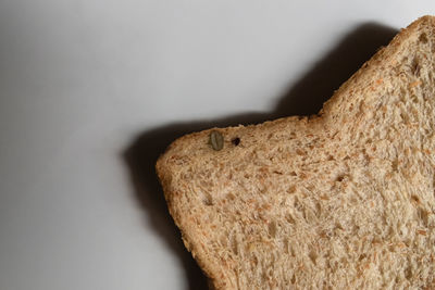 Close-up of bread on table against white background