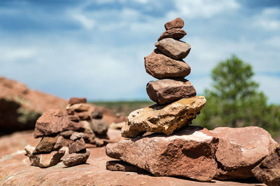 Stack of stones on rock against sky