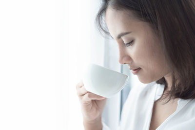 Close-up portrait of a woman drinking coffee