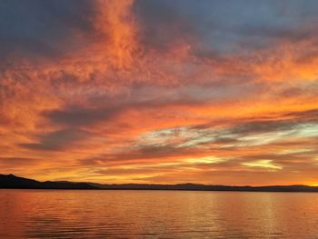 Scenic view of sea against dramatic sky during sunset