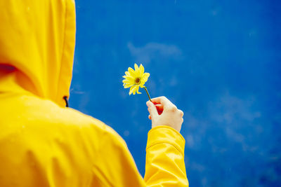 Midsection of man holding yellow flower