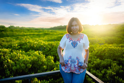 Woman standing on field against sky