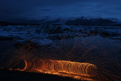 Aerial view of illuminated landscape against sky at night