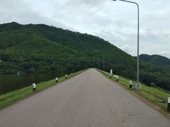 Road amidst green landscape against sky