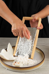 Parut kelapa, female asian woman making shredded or grated coconut