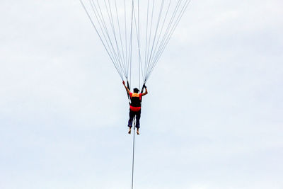 Low angle view of people flying against sky