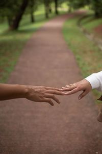 Midsection of woman holding hands against blurred background