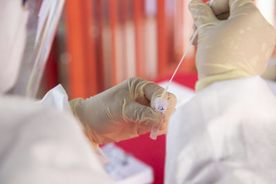 Medical officer mix a swab test sample with liquid to do a rtk-ag test for covid-19 virus.