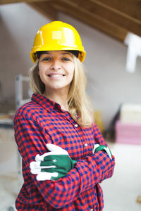 Portrait of smiling woman standing at construction site