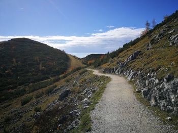 Road leading towards mountain against sky