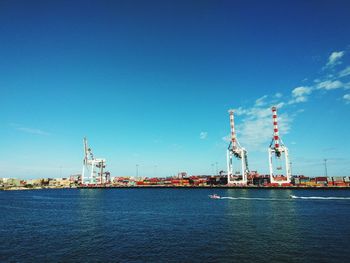 Commercial dock by sea against blue sky