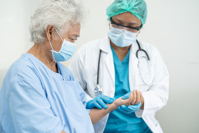 Smiling female doctor examining patient in hospital