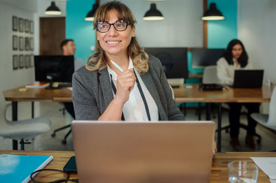 Cheerful woman with laptop in cafe