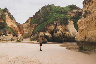 Rear view of woman walking at beach