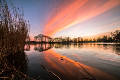 Scenic view of lake against orange sky