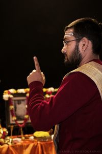 Side view of young man standing against glass at night