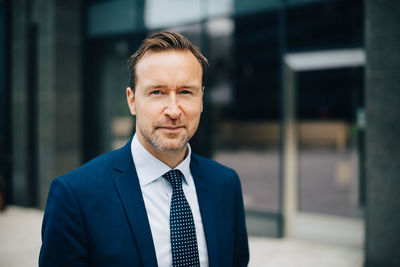 Portrait of confident mature businessman standing in city