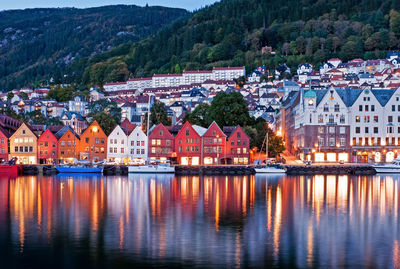 Houses by river and buildings in city