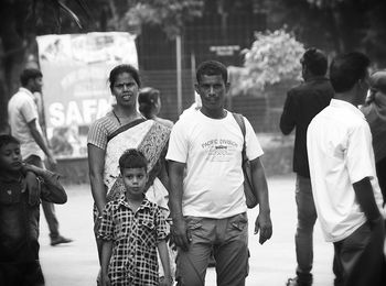 Portrait of men with people in background