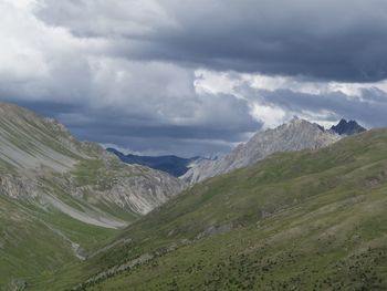 Scenic view of mountain range against cloudy sky