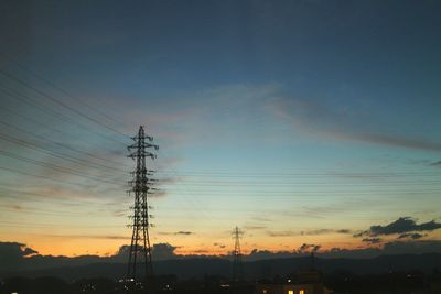 Low angle view of electricity pylon against dramatic sky