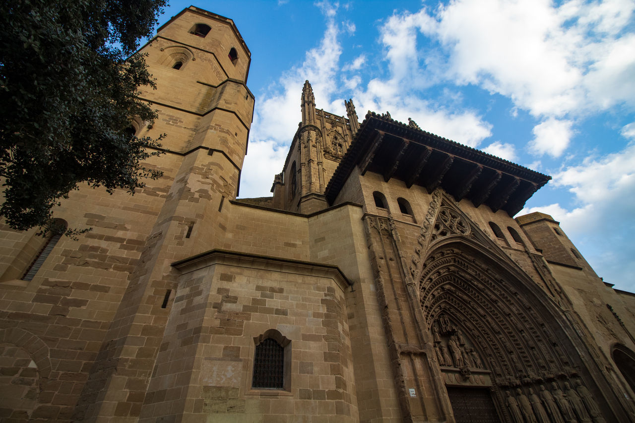 low angle view, architecture, built structure, sky, building exterior, belief, religion, spirituality, place of worship, cloud - sky, building, nature, no people, the past, day, history, travel destinations, outdoors, gothic style