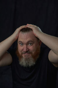 Portrait of young man against black background