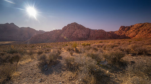 Scenic view of mountains against bright sun