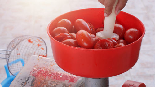 Close-up of hand holding red bowl