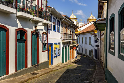 Street with old colonial-style houses and sunlit cobblestones in the historic city of ouro preto