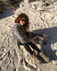 Portrait of man wearing sunglasses on sand at beach