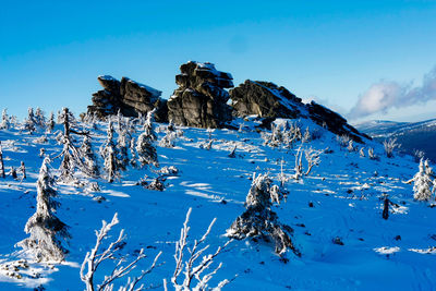 Scenic view of snow covered mountains against blue sky