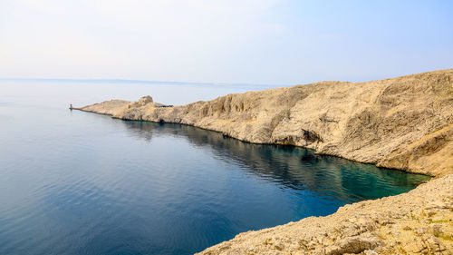 Rock formation in sea against sky