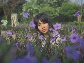 Girl with purple flowers on field