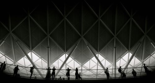 Silhouette people standing on bridge at night