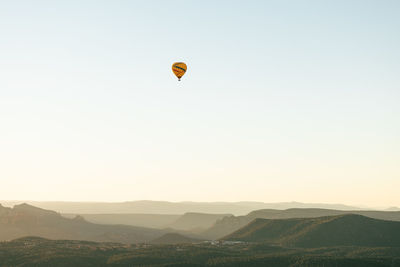 Horizontal image of wide shot of hot air balloon isolated against white sky background