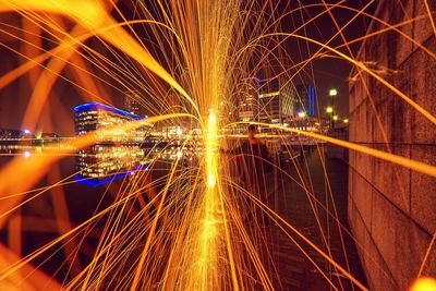 Sparks of light with illuminated built structures in distance