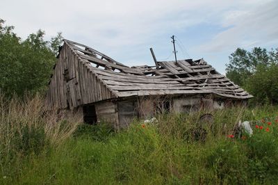 Abandoned house on field against sky