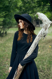 Young woman wearing hat standing on field