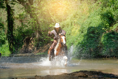 Man horseback riding in lake