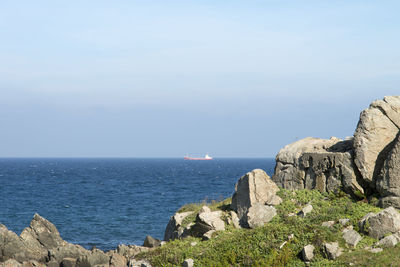 Scenic view of cliff by sea against sky