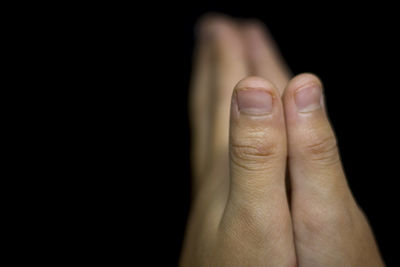 Close-up of human hand against black background