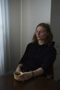 Sad woman sitting with cup of coffee