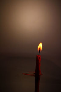 Close-up of illuminated candle on table