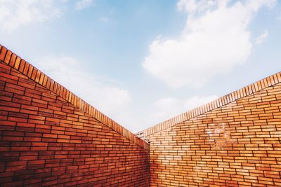 Low angle view of brick wall against sky