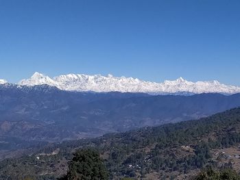 Scenic view of snowcapped mountains against clear blue sky